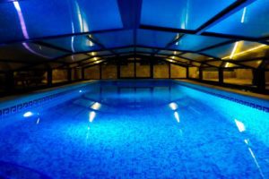 enclosed indoor pool at night with lights