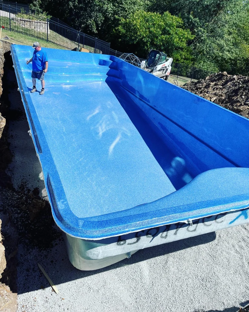 Fiberglass pool shell being set during installation