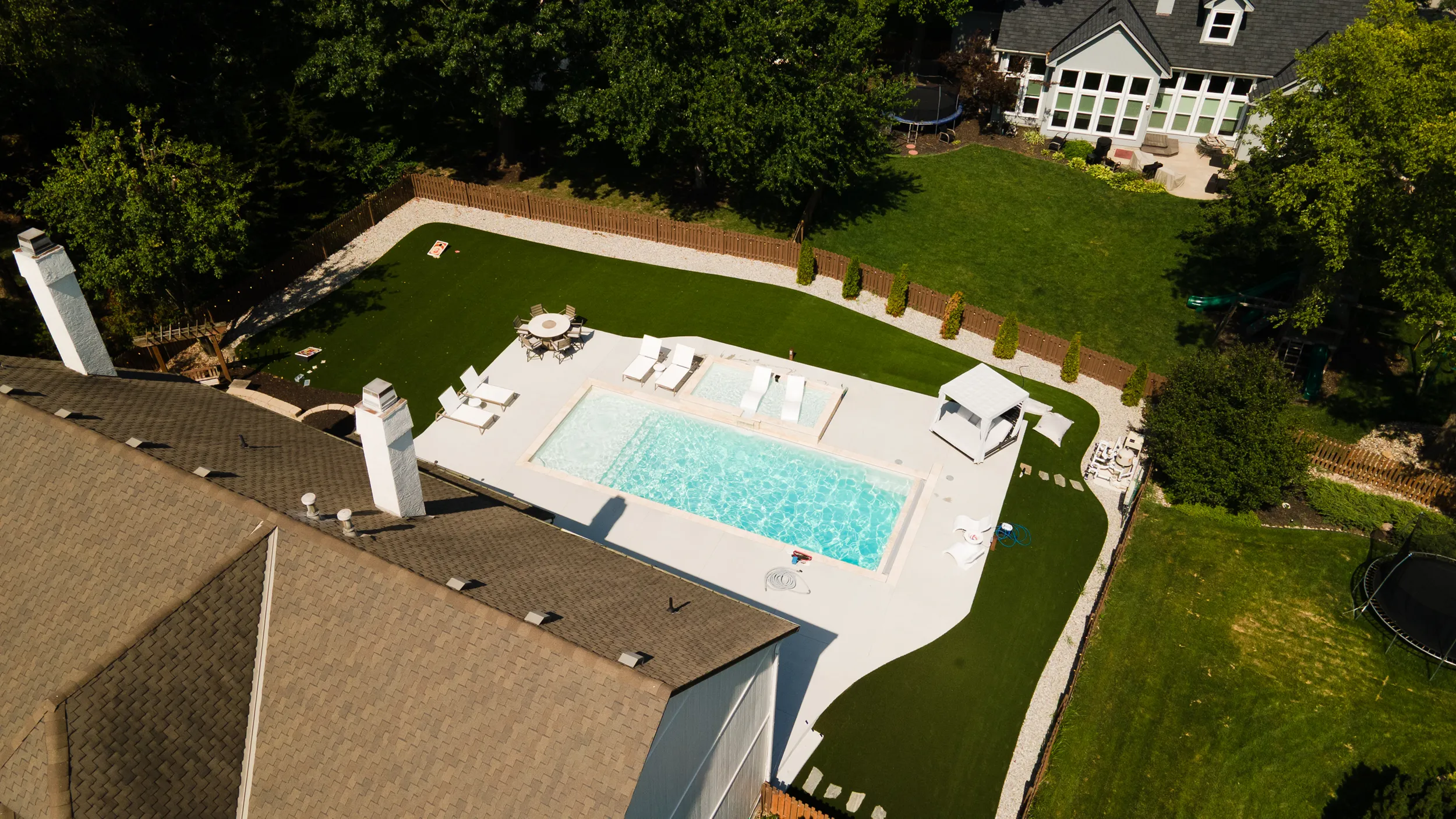 Aerial view of a rectangular fiberglass pool with turf surround