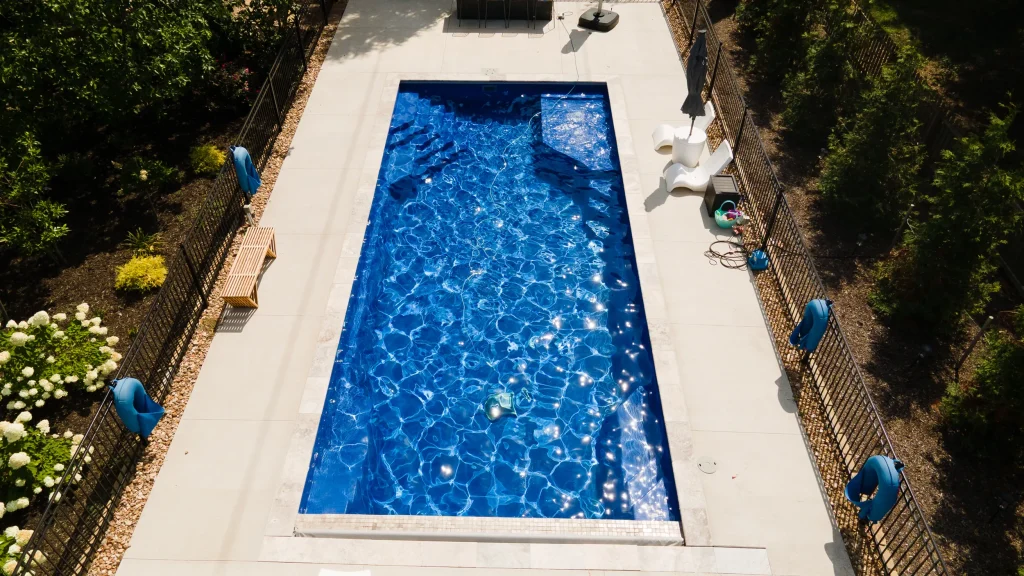 Overhead view of a rectangular fiberglass pool with entry steps