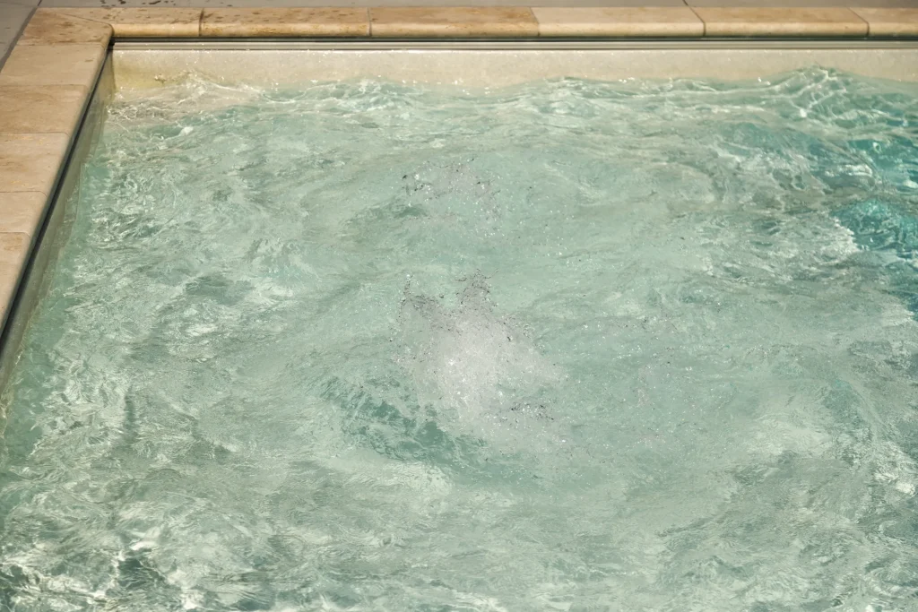 Bubbling water in a spa built alongside a fiberglass pool
