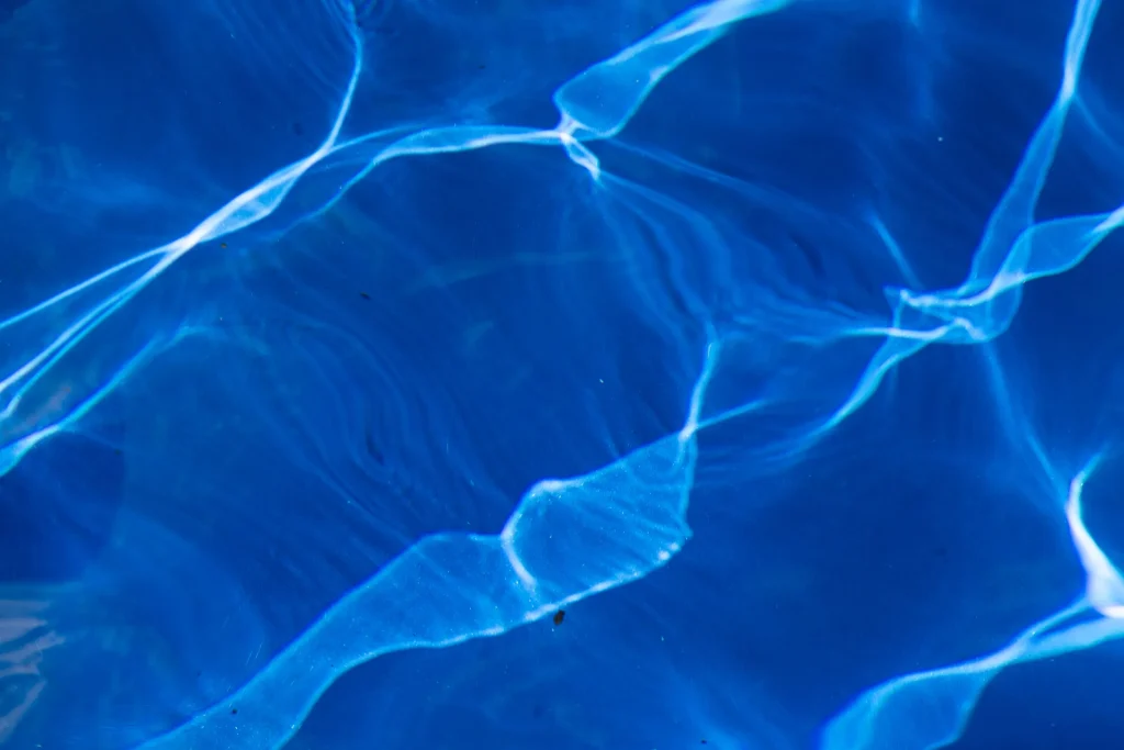 Sunlight reflecting on clear blue pool water