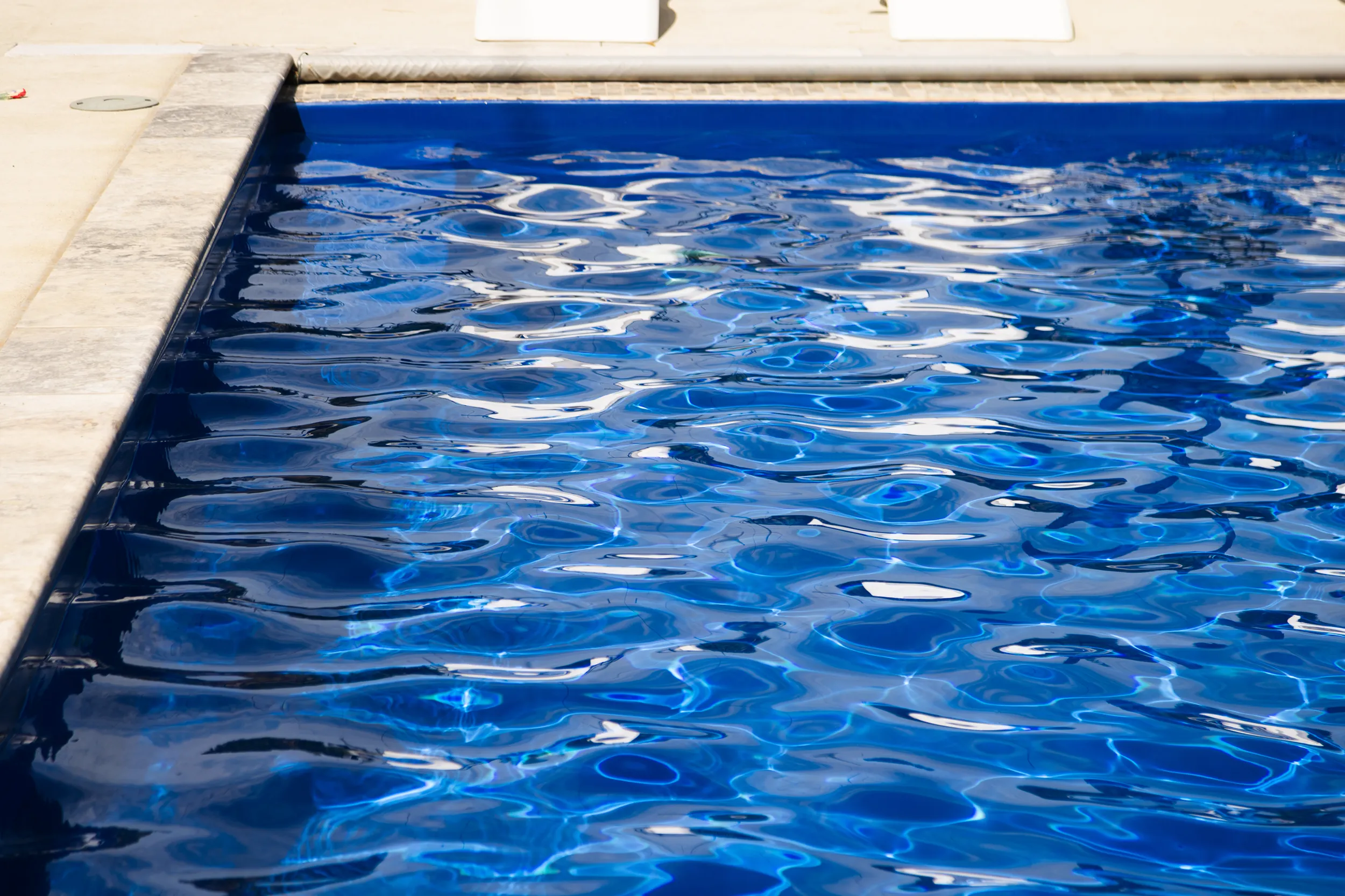 Sparkling blue water in a rectangular fiberglass pool